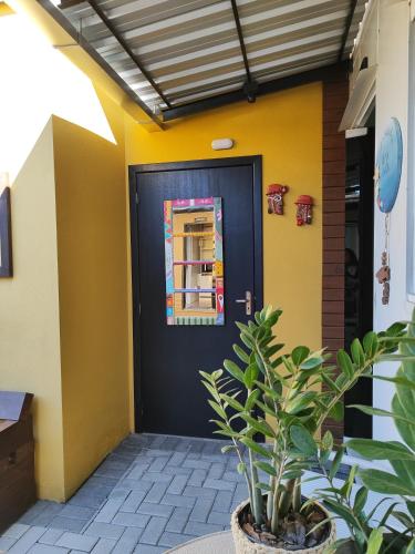 a black door with a window and a plant at Maga hospedagem in Penha