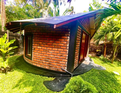 a small brick house with a blue roof at Ritter Kreuz Cabana Resort in Tangalle