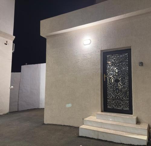 a door on the side of a building with stairs at شقق الاطاولة المفروشة in Āl Ţāwilah