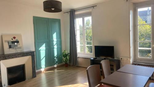 Una sala de estar con una mesa y una chimenea. en Meaux Centre 2 Vue cathédrale, en Meaux