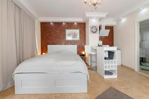 a bedroom with a white bed and a desk at Apartment in der City in Sankt Wendel