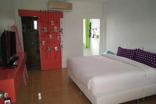 a bedroom with a bed and a red door at Na-Rak-O Resort in Chiang Rai