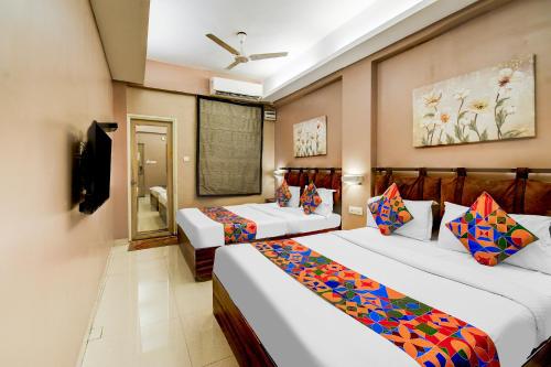 a hotel room with two beds and a television at FabHotel Arastu Plaza - Nr Nampally Railway Station in Hyderabad