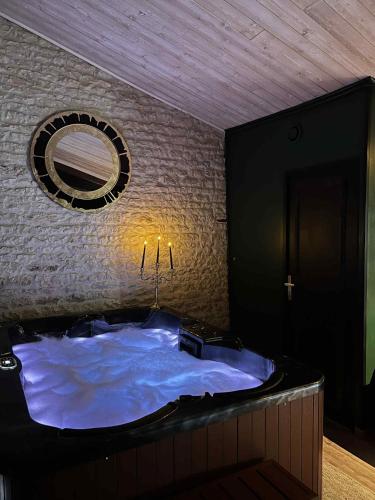 - une grande baignoire bleue dans une chambre avec un mur dans l'établissement Gîte de charme romantique avec Spa privatif l'Echappée bulles, à Chambon
