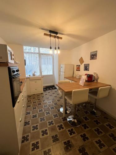 a kitchen with a wooden table and a kitchen with a floor at Le nid Cévenol in Sumène