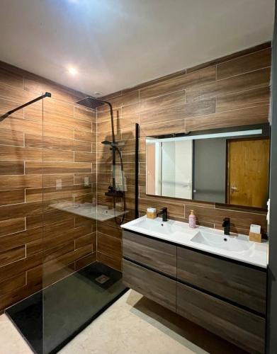 a bathroom with a sink and a shower and a mirror at Le nid Cévenol in Sumène