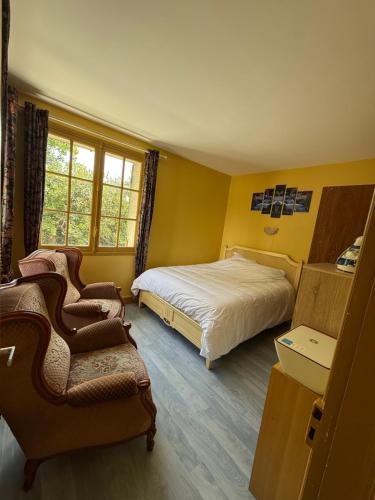 a yellow bedroom with a bed and a chair at Appartement au bord de la mer in Houlgate