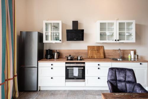 a kitchen with white cabinets and a refrigerator at Storchenhof Blumenow in Blumenow