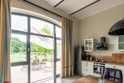 a kitchen with a large glass door leading to a patio at Storchenhof Blumenow in Blumenow