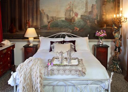 a white bed with a tray with two candles on it at Arnaboldi Palace in Pavia