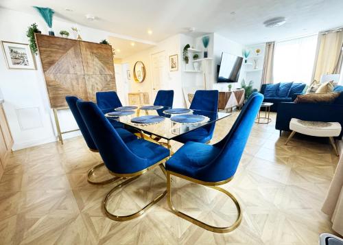 a dining room with a glass table and blue chairs at Big Ben Panorama, Parliament View, 3 bedrooms, Central London, Luxurious flat for 6 guests in London