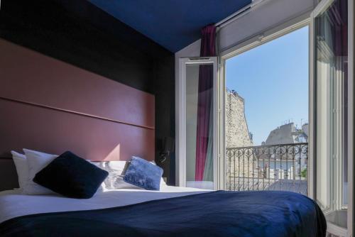 a bedroom with a bed and a large window at Accueil Hôtel Paris Pigalle Montmartre - Hôtel rénové in Paris