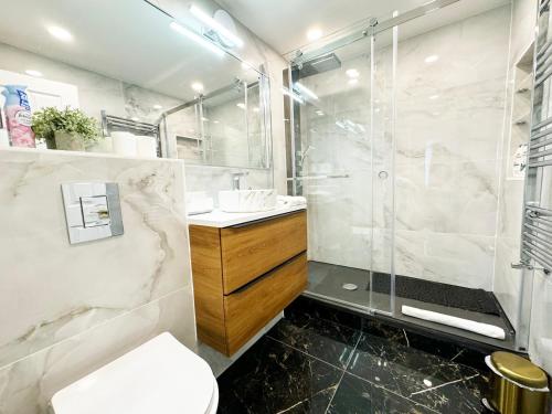 a bathroom with a shower and a toilet and a sink at Big Ben Panorama, Parliament View, 3 bedrooms, Central London, Luxurious flat for 6 guests in London