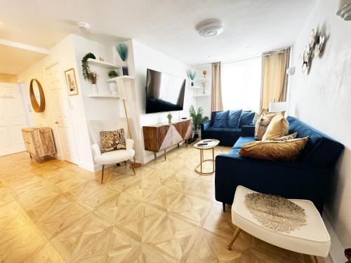 a living room with a blue couch and a tv at Big Ben Panorama, Parliament View, 3 bedrooms, Central London, Luxurious flat for 6 guests in London