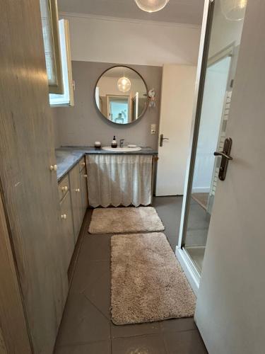 une salle de bain avec un lavabo et un miroir dans l'établissement Longère pornicaise avec piscine chauffée, à Pornic