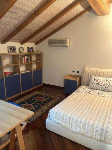 a bedroom with a bed and a desk and a table at Penthouse Orta Imagine the Lake in Orta San Giulio