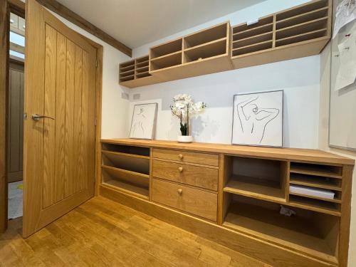 a dressing room with a wooden dresser and shelves at The Barn Heathfield in Heathfield