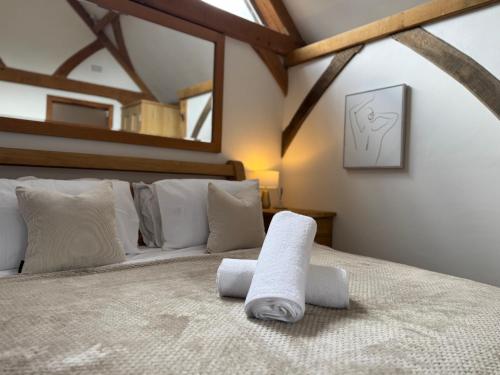 a bedroom with a large bed with towels on it at The Barn Heathfield in Heathfield