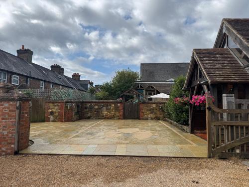 a courtyard with a fence and a wooden gate at The Barn Heathfield in Heathfield