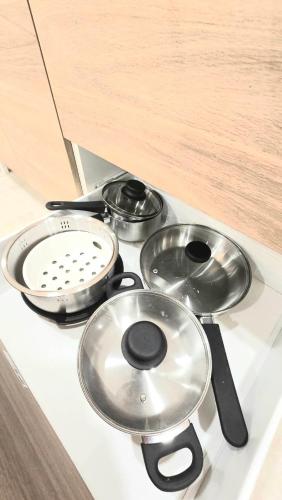 a stove top with three pots and pans on it at Kiddie Hostel 13A1-Kids and pets friendly in Kababae
