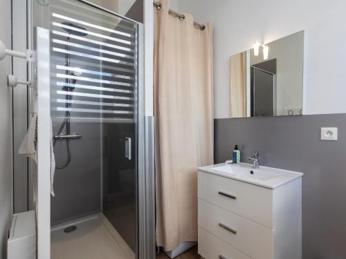 a bathroom with a shower and a sink and a mirror at Ty Ker by Madame Est Servie in Pleumeur-Bodou
