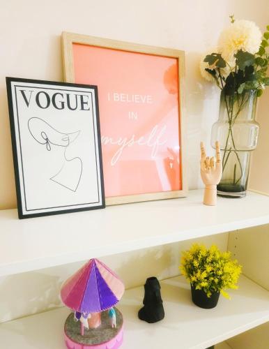a shelf with a framed picture and flowers at Kiddie Hostel 13A1-Kids and pets friendly in Kababae