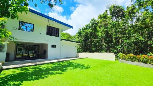 a house with a green lawn in front of it at Kiddie Hostel 13A1-Kids and pets friendly in Kababae