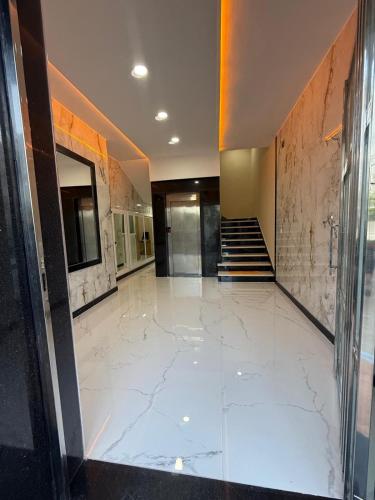 a lobby with a marble floor and a staircase at Appart Résidence Sabrin in Fnidek