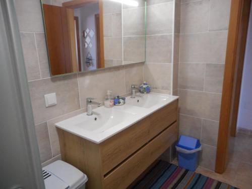 a bathroom with a sink and a mirror and a toilet at Appartement à LOURINHA - 1er étage in Lourinhã