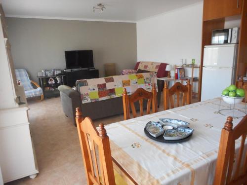 a kitchen and living room with a table and a couch at Appartement à LOURINHA - 1er étage in Lourinhã