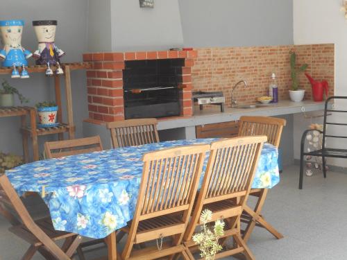 a kitchen with a table with chairs and a fireplace at Appartement à LOURINHA - 1er étage in Lourinhã
