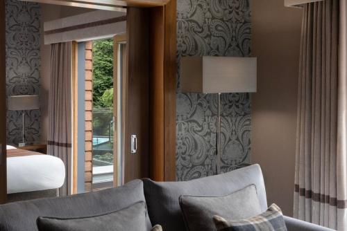 a living room with a couch and a bed at Fonab Castle Hotel in Pitlochry