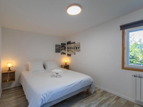 a bedroom with a white bed and a window at Ty Bihan by Madame Est Servie in Pleumeur-Bodou