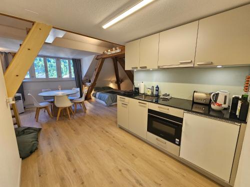 a kitchen with a table and a dining room at Premium Apartments - central & historical in Meiringen