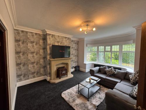 a living room with a couch and a fireplace at Shubh stays in Buxton