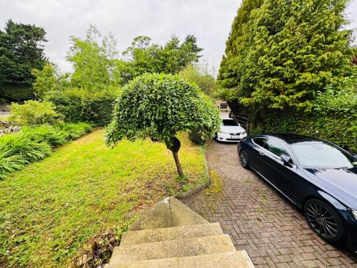 a black car parked next to a small tree at Shubh stays in Buxton