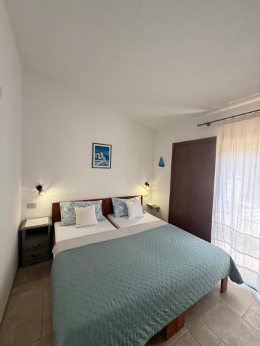 a bedroom with a large bed and a window at Villa Oliva in Costa Paradiso
