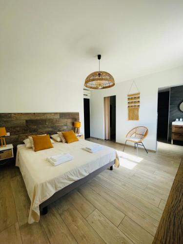 une chambre avec un grand lit et une chaise dans l'établissement Villa, à Roquebrune-sur Argens