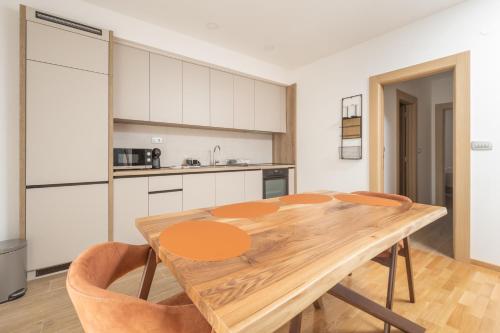 a kitchen with a wooden table and chairs at Autentica Apart in Cetinje