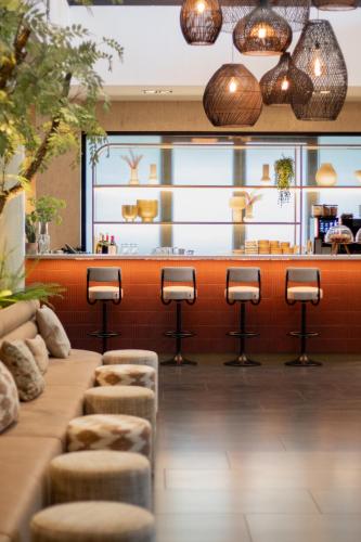 a bar in a restaurant with stools in front of a counter at Van der Valk Hotel Vianen - Utrecht in Vianen
