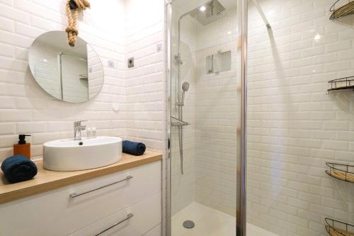 a white bathroom with a sink and a shower at Beautiful apartment located 5 min from the beaches in La Garde
