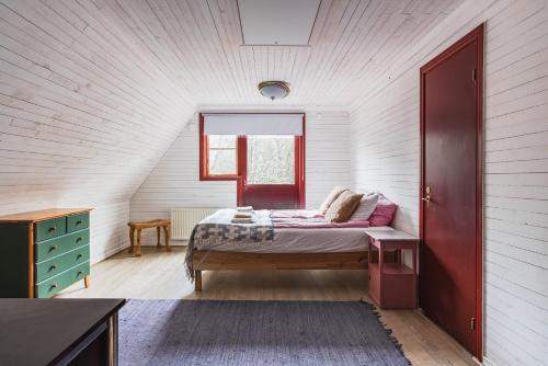 a bedroom with a bed in a white room at Charming Forest Retreat, 15 Min from Mariefred in Nykvarn