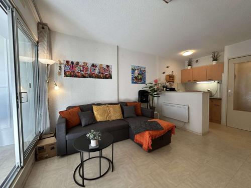 un salon avec un canapé et une table dans l'établissement Studio cabine 4 pers, parking à 1100m plage Richelieu - FR-1-249-421, au Cap d'Agde