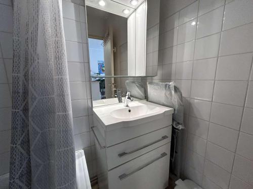 une salle de bain blanche avec un lavabo et un miroir dans l'établissement Studio cabine 4 pers, parking à 1100m plage Richelieu - FR-1-249-421, au Cap d'Agde