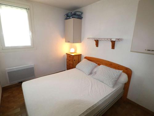 - une petite chambre avec un lit blanc et une fenêtre dans l'établissement Appartement T2 avec terrasse et parking à 350m de la plage, proche commerces. - FR-1-307-217, au Grau-du-Roi