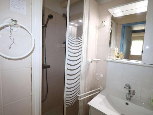 une salle de bain avec une douche, un lavabo et un miroir dans l'établissement Appartement T2 avec terrasse et parking à 350m de la plage, proche commerces. - FR-1-307-217, au Grau-du-Roi