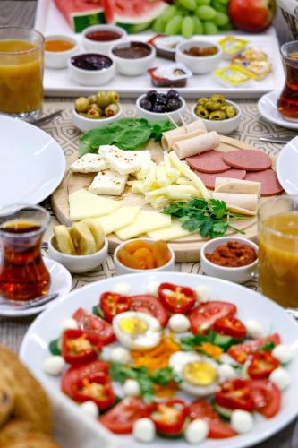 a table topped with plates of food with eggs and tomatoes at Gezgin Hotel in Edirne