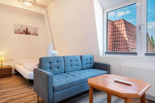 a living room with a blue couch and a table at Die Alter Schwede Wohnung 3 in Vechta