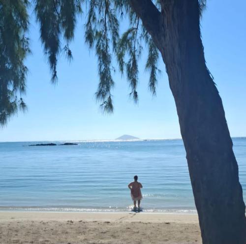 a person standing on a beach near the water at Kot Nou - Kwizine Mama Manze Lakaz in Mahébourg