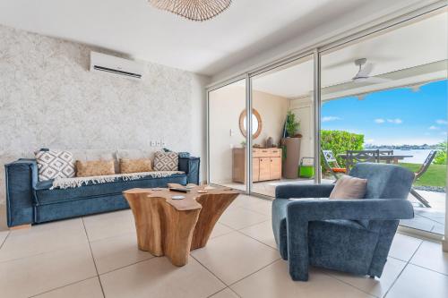 a living room with a couch and a chair and a table at Refait à neuf, magnifique vue sur le lagon appartement 4 à 5p in Marigot